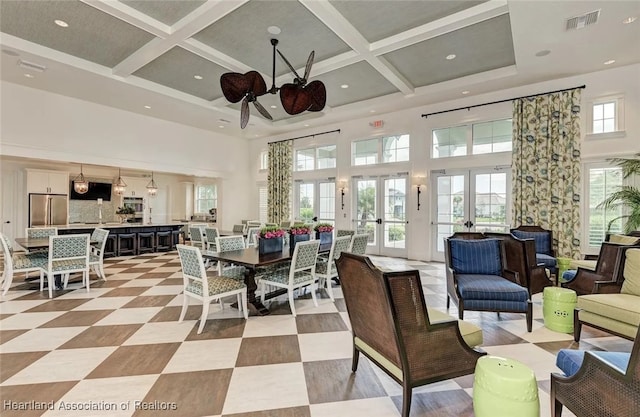 interior space featuring coffered ceiling, ceiling fan, a high ceiling, and french doors