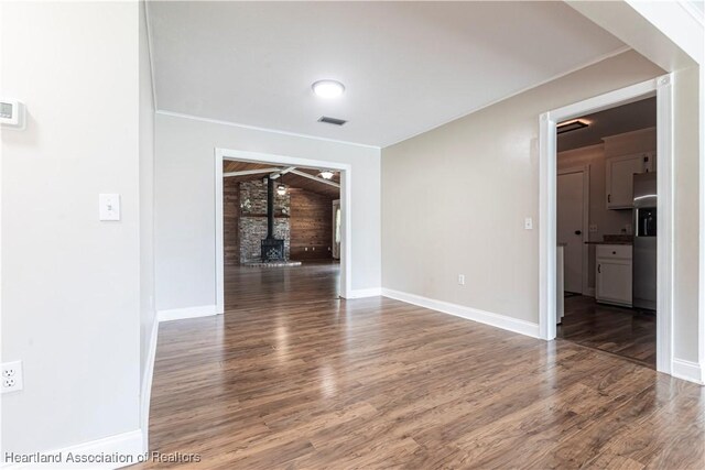 1090 Knollwood Cir, Wauchula, FL 33873 - spare room with a wood stove, wood finished floors, and wood walls