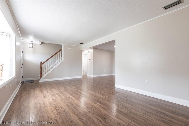 1090 Knollwood Cir, Wauchula, FL 33873 - unfurnished living room with stairs, wood finished floors, a textured ceiling, and crown molding