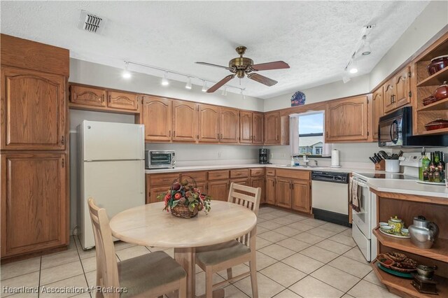 kitchen featuring open shelves, light countertops, a sink, a textured ceiling, and white appliances