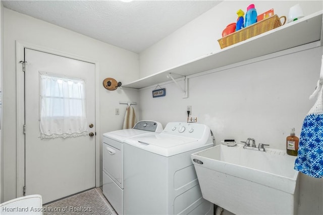 washroom with independent washer and dryer, laundry area, a sink, and a textured ceiling