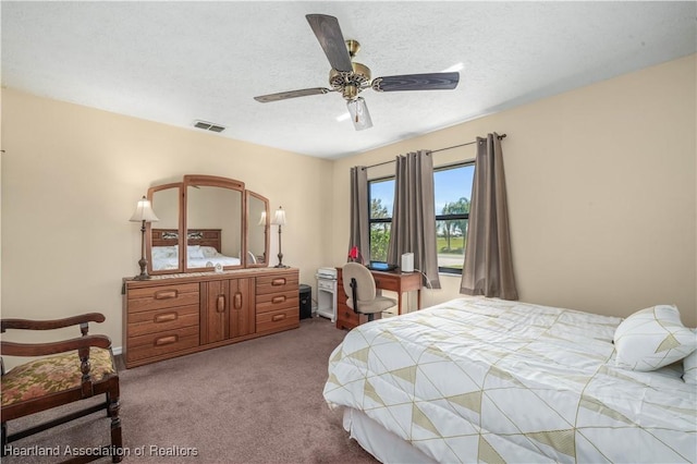 carpeted bedroom featuring a textured ceiling, ceiling fan, and visible vents