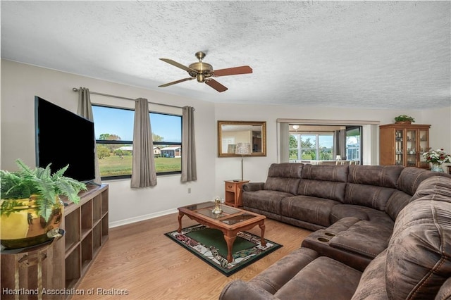 living area with light wood-style floors, a textured ceiling, and a wealth of natural light