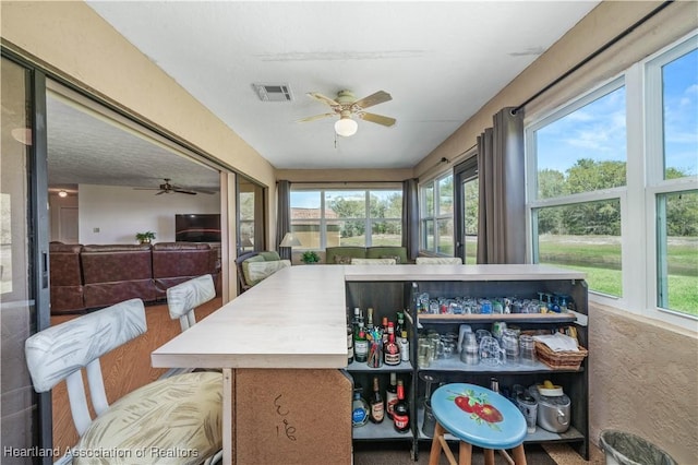 sunroom with ceiling fan and visible vents