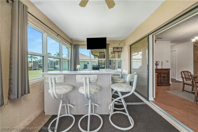 sunroom / solarium featuring ceiling fan