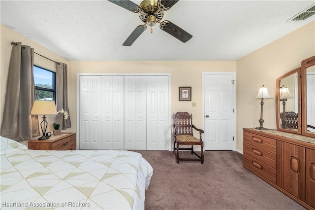 carpeted bedroom featuring a textured ceiling, ceiling fan, a closet, and visible vents