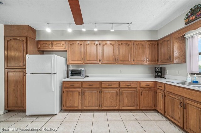 kitchen with freestanding refrigerator and brown cabinets