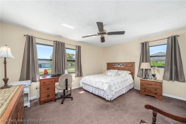 carpeted bedroom with a ceiling fan, a textured ceiling, and baseboards