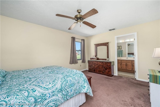 carpeted bedroom featuring baseboards, visible vents, ceiling fan, and ensuite bathroom