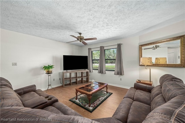 living area with a ceiling fan, baseboards, and wood finished floors