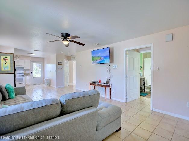 224 Montego Dr, Sebring, FL 33870 - living area with light tile patterned floors, baseboards, and a ceiling fan