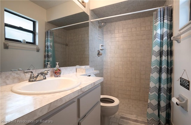 bathroom featuring toilet, a tile shower, and vanity