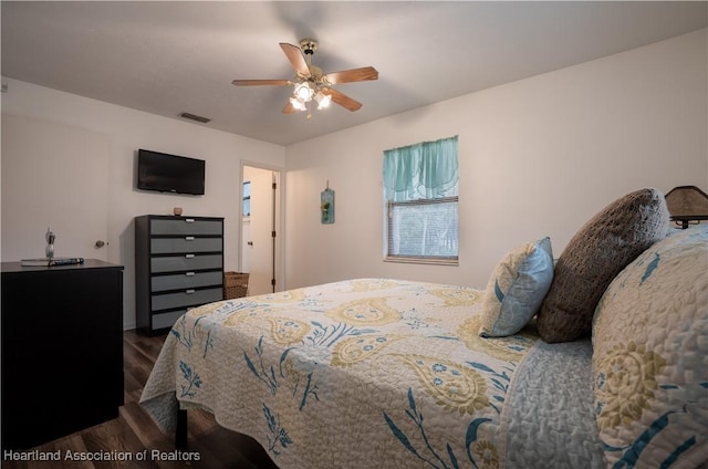 bedroom featuring ceiling fan, visible vents, and wood finished floors