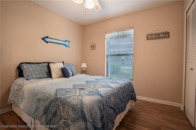 bedroom featuring baseboards, wood finished floors, and a closet