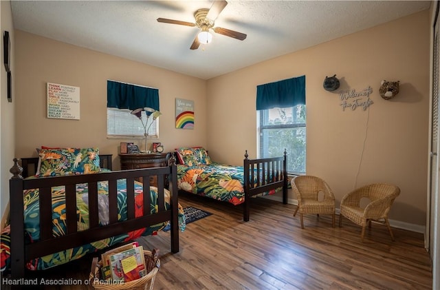 bedroom featuring baseboards, a ceiling fan, and wood finished floors