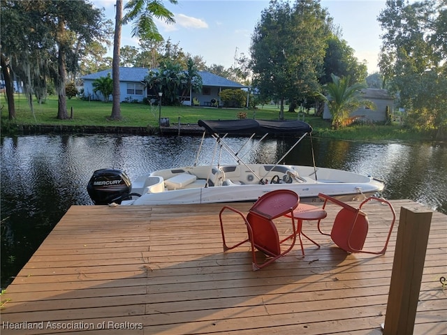 dock area with a water view and a yard