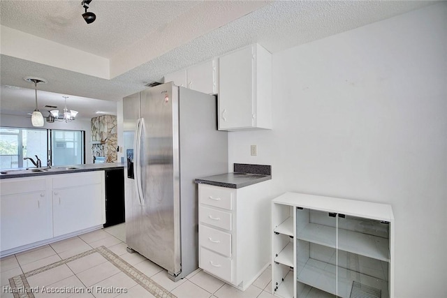 kitchen with stainless steel fridge, sink, white cabinetry, hanging light fixtures, and light tile patterned flooring