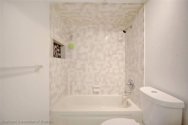 bathroom featuring toilet and tiled shower / bath