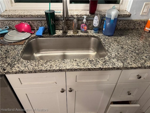 details featuring white cabinetry and sink