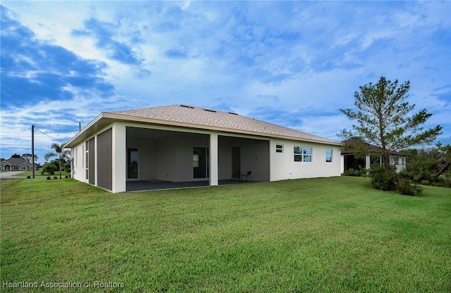 rear view of house with a lawn and a sunroom