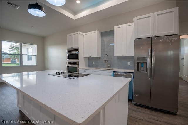 kitchen with pendant lighting, sink, a kitchen island, and stainless steel appliances