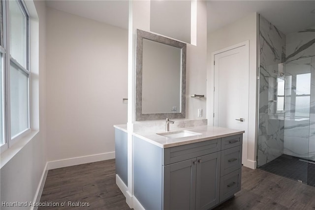 bathroom featuring hardwood / wood-style flooring, vanity, and tiled shower