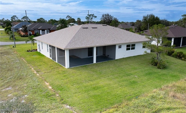 rear view of property with a lawn and a sunroom