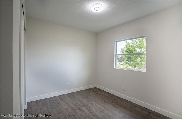 unfurnished room featuring dark hardwood / wood-style floors and a textured ceiling