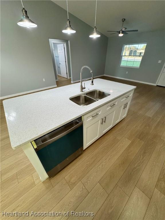 kitchen with white cabinetry, an island with sink, dishwasher, hanging light fixtures, and sink