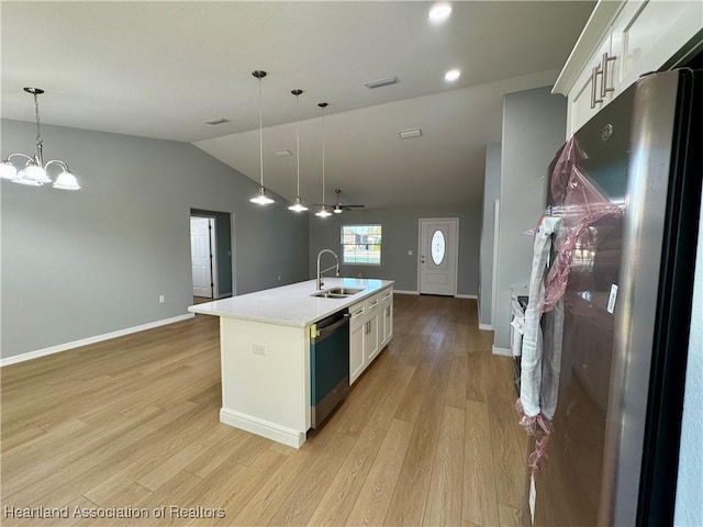 kitchen featuring white cabinets, stainless steel appliances, sink, hanging light fixtures, and a kitchen island with sink