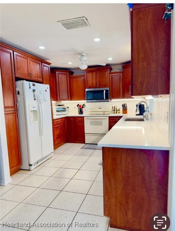 315 Sirena Dr, Lake Placid, FL 33852 - kitchen featuring a sink, white appliances, dark brown cabinets, and light countertops