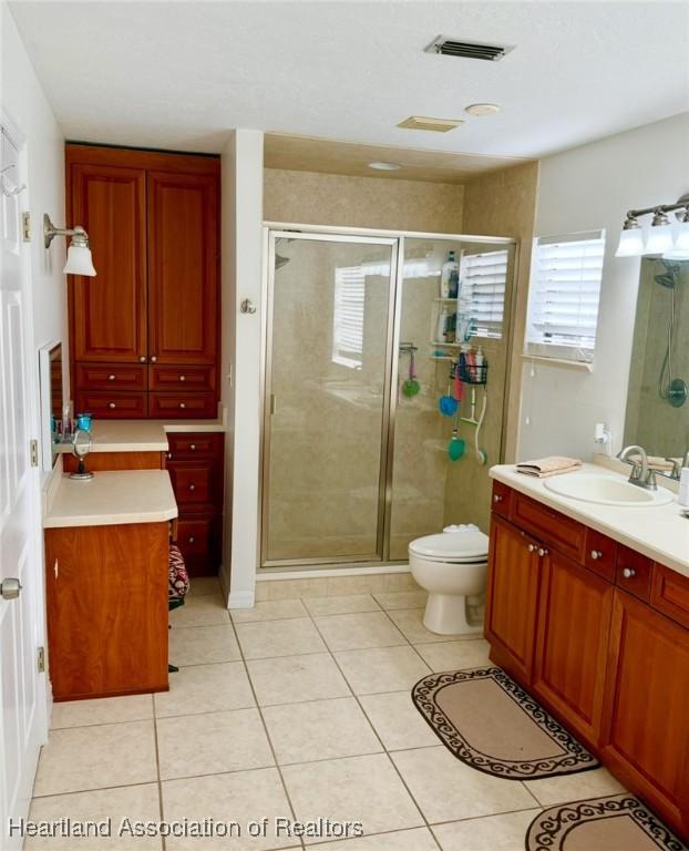 315 Sirena Dr, Lake Placid, FL 33852 - bathroom featuring tile patterned flooring, visible vents, toilet, a stall shower, and vanity