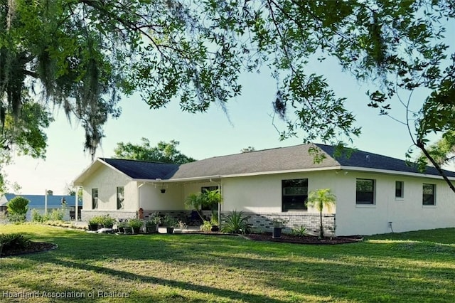 315 Sirena Dr, Lake Placid, FL 33852 - rear view of property with stucco siding, a lawn, and brick siding