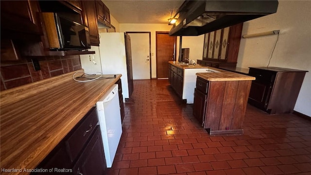 kitchen featuring brick floor, white appliances, a sink, wooden counters, and backsplash