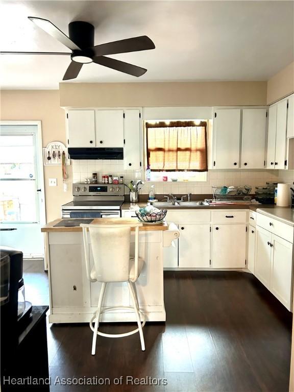 kitchen featuring dark hardwood / wood-style flooring, white cabinetry, electric range, and backsplash