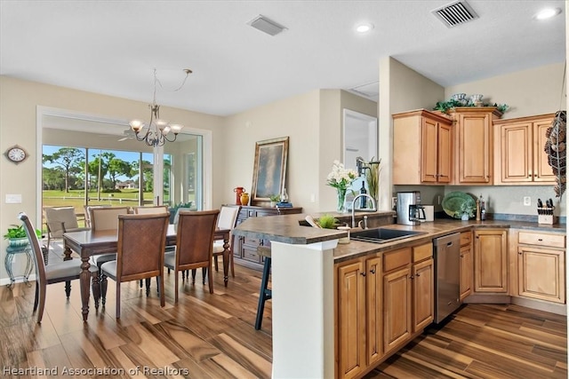 kitchen featuring dishwasher, sink, decorative light fixtures, kitchen peninsula, and a chandelier