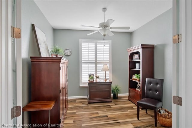 living area with ceiling fan and light hardwood / wood-style flooring