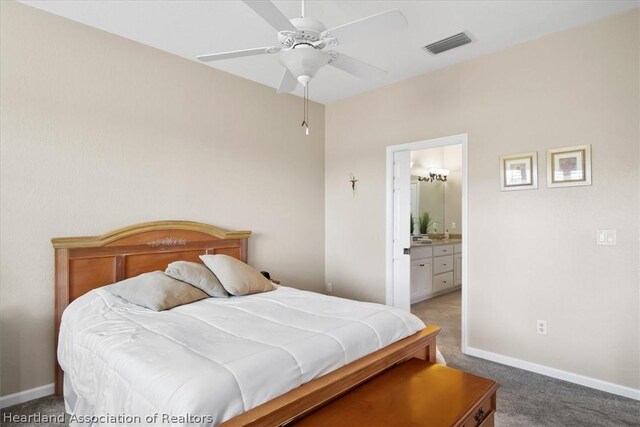 carpeted bedroom with ceiling fan and ensuite bath