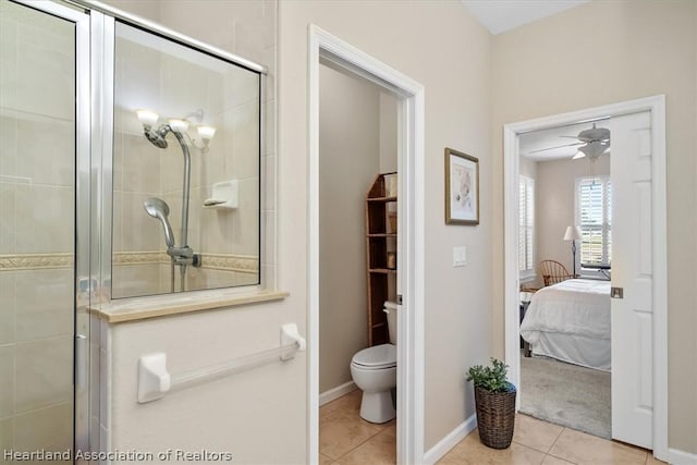 bathroom with tile patterned flooring, ceiling fan, toilet, and a shower with shower door