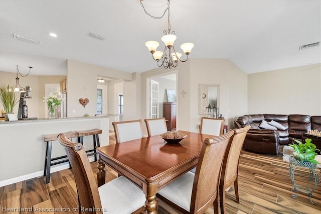 dining room featuring light wood-type flooring and a notable chandelier