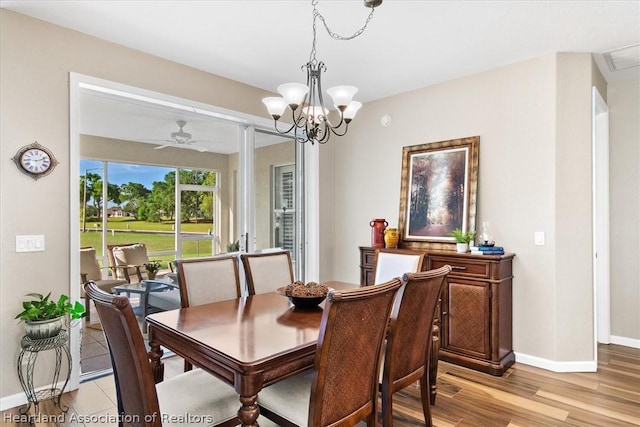 dining room featuring ceiling fan with notable chandelier and light hardwood / wood-style floors