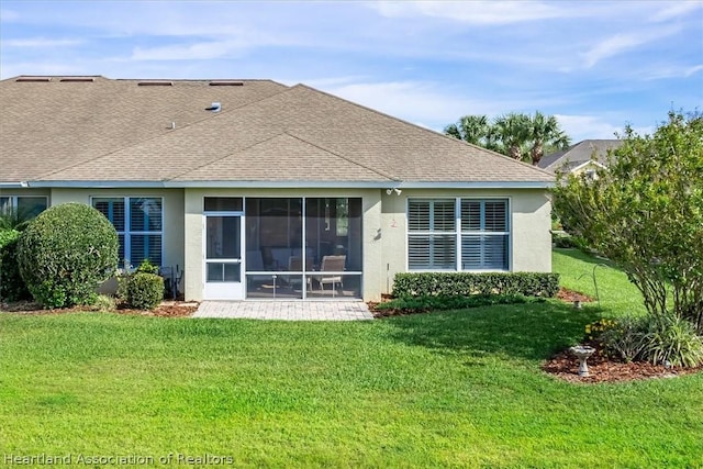 rear view of house featuring a yard and a sunroom