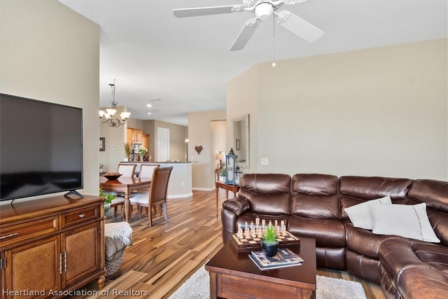 living room with light hardwood / wood-style flooring and ceiling fan with notable chandelier