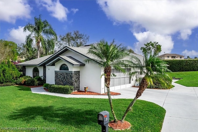 view of front of property with a garage, a front yard, driveway, and stucco siding