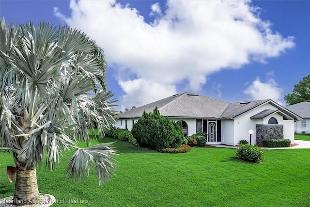 view of front of property with a garage, driveway, a front lawn, and stucco siding