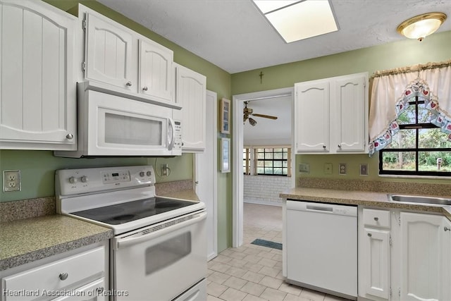 kitchen featuring brick wall, white appliances, ceiling fan, sink, and white cabinetry