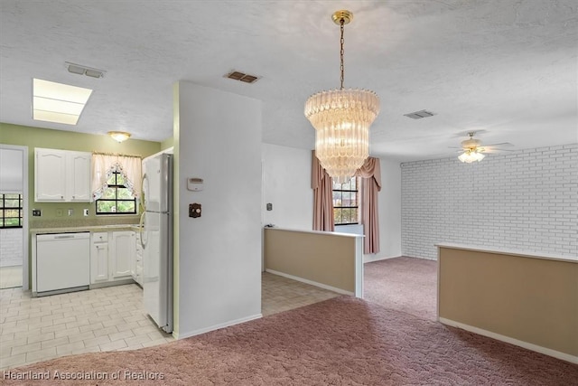 kitchen featuring white cabinetry, a healthy amount of sunlight, white appliances, and light carpet