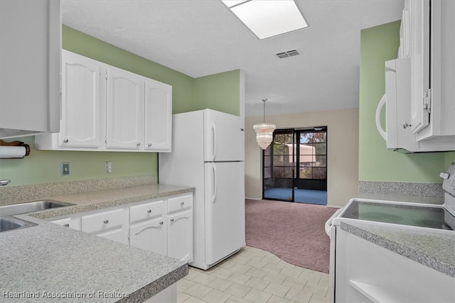 kitchen featuring white cabinetry, sink, decorative light fixtures, white appliances, and light carpet