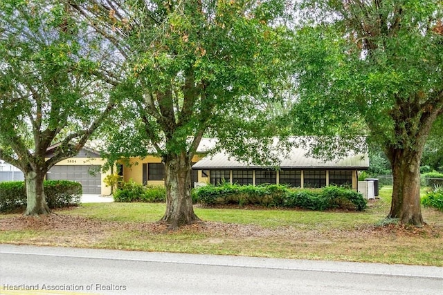 ranch-style house featuring a garage and a front lawn