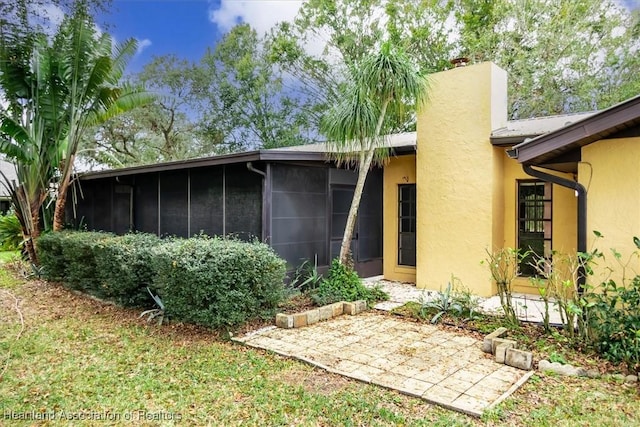 rear view of property featuring a sunroom